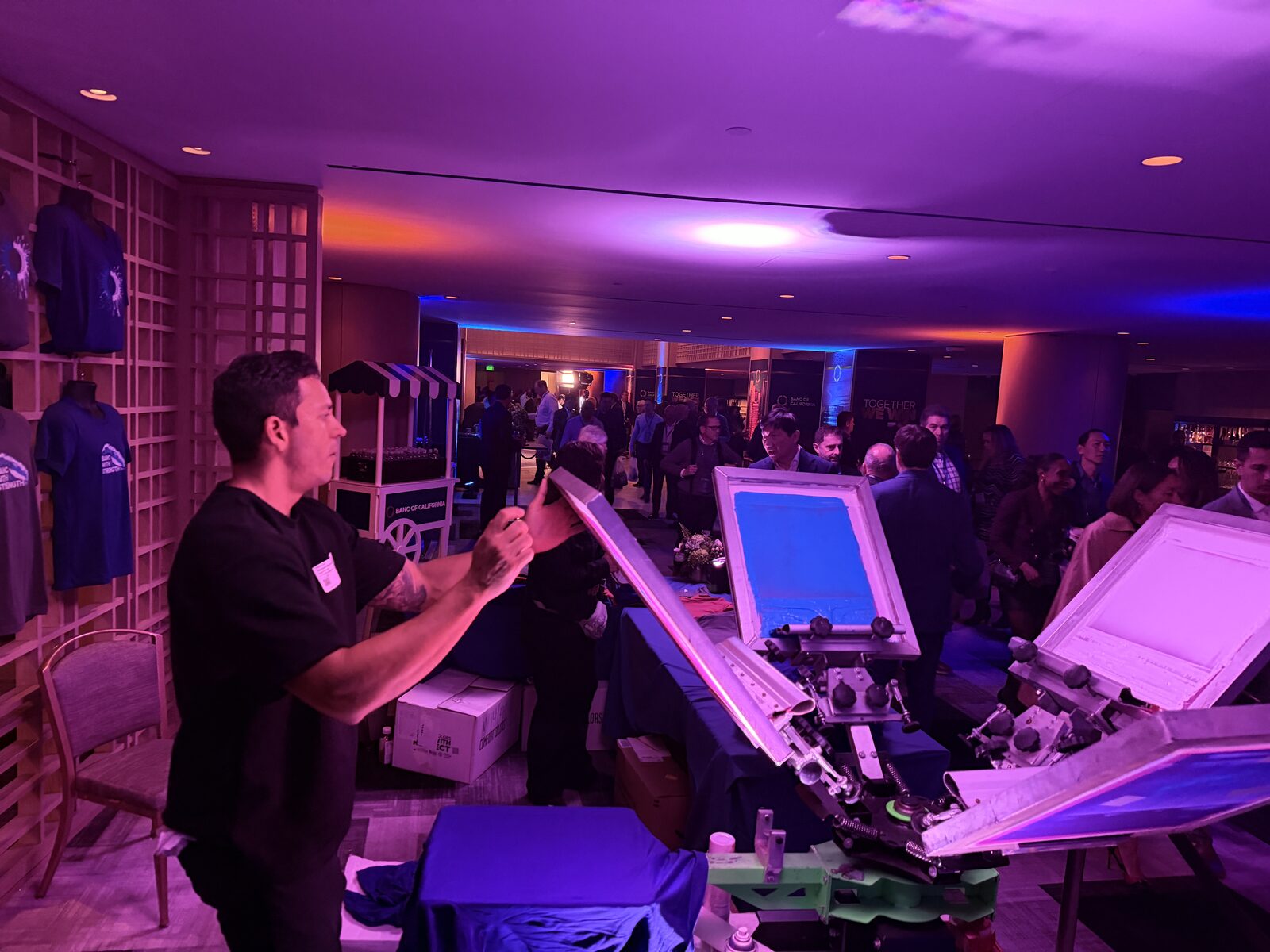 Personalization station operating under purple uplighting at a corporate gala