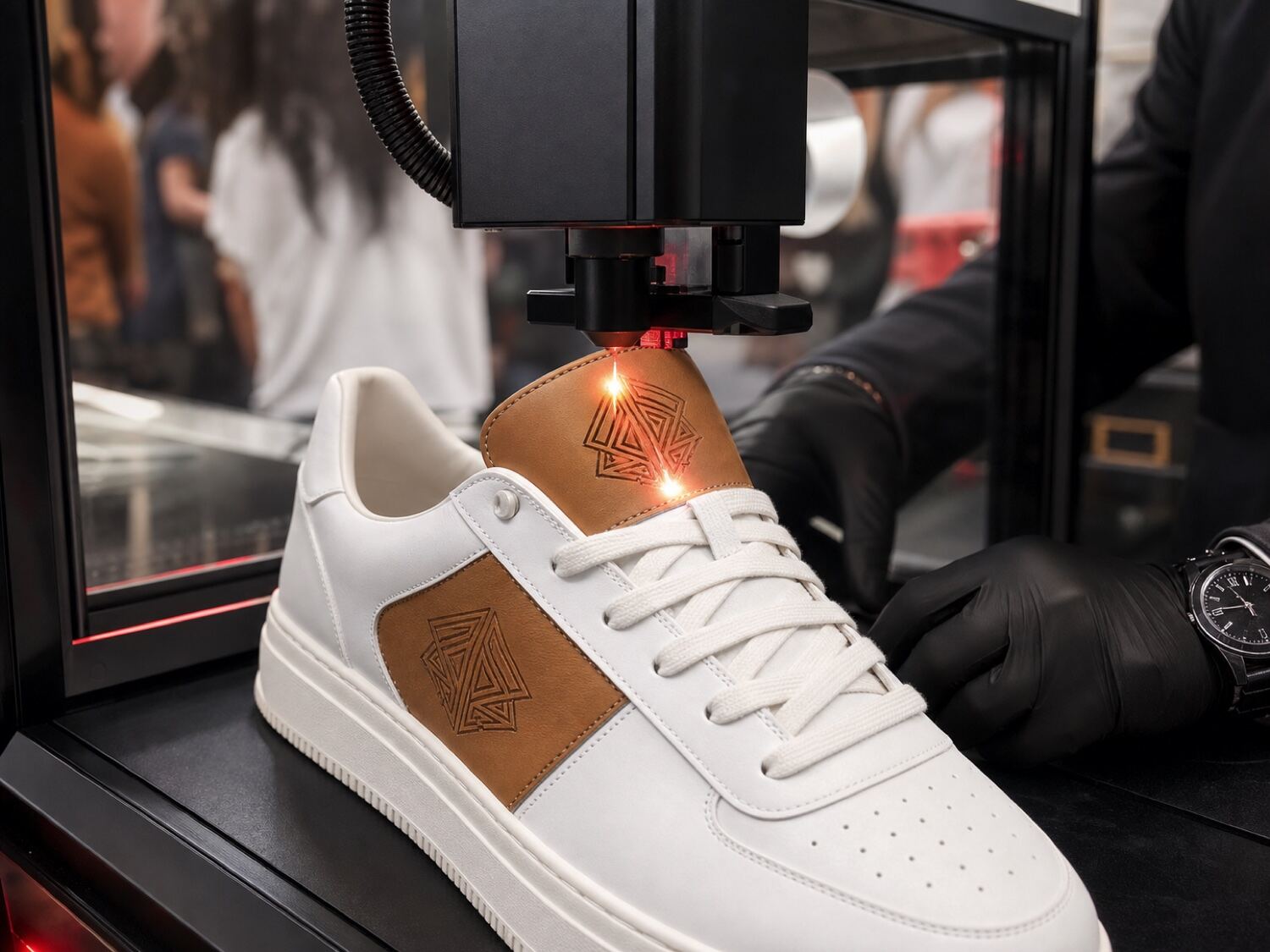 Laser engraving a monogram onto the leather side panel of a white sneaker